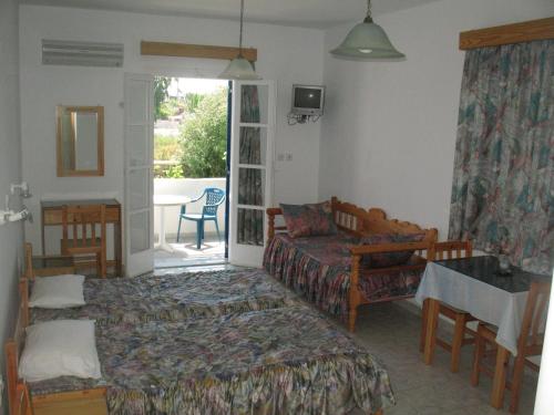 a bedroom with a bed and a couch and a table at Mavromatis Studios in Naxos Chora