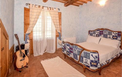 Un dormitorio con una cama y una guitarra. en 3 Bedroom Awesome Home In Civitella Dagliano, en Civitella dʼAgliano