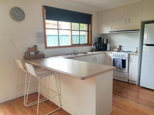 a kitchen with a counter and a sink and a refrigerator at Olive Street Apartment in Albury