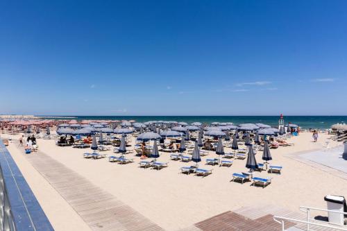 een strand met stoelen en parasols en de oceaan bij Levante apartment and room in Bari