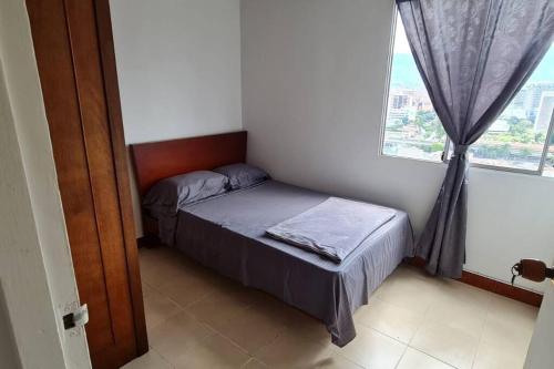 um pequeno quarto com uma cama e uma janela em Hermoso Apartamento en excelente ubicación. em Medellín