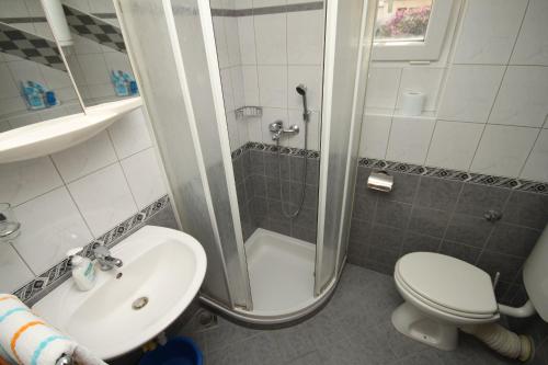 ein Bad mit einer Dusche, einem WC und einem Waschbecken in der Unterkunft Apartments by the sea Baska Voda, Makarska - 6869 in Baška Voda