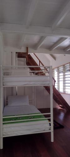 Cette chambre comprend un lit superposé blanc avec un escalier. dans l'établissement Gingerbread Cottage and Studio Fiji, à Savusavu