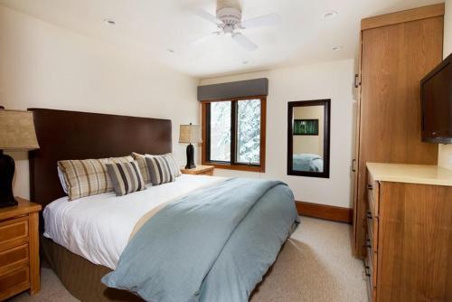 um quarto com uma cama grande e uma televisão em 3 Bedroom Mountain Residence In The Heart Of Aspen With Amenities Including Heated Pool, Hot Tubs, Game Room And Spa em Aspen