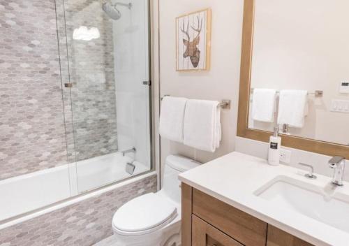 y baño con aseo, ducha y lavamanos. en 3 Bedroom Mountain Residence In The Heart Of Aspen With Amenities Including Heated Pool, Hot Tubs, Game Room And Spa en Aspen