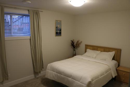 a bedroom with a white bed and a window at Guest Suite in Calgary in Calgary