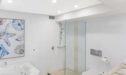 een witte badkamer met een douche en een toilet bij Little Cove Court - Apt 4 in Noosa Heads