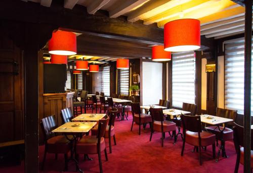 エヴルーにあるHotel de Normandieのダイニングルーム(テーブル、椅子、赤いランプ付)