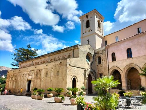 an old building with a clock tower and a church at Appartamenti MiNuMa Tropea in Tropea