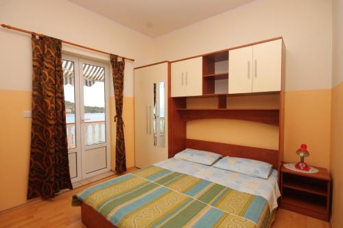 a bedroom with a bed and a large window at Apartments by the sea Kali, Ugljan - 8234 in Kali