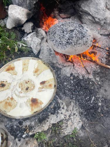 a fire with two plates on top of it at Bujtina Brahim Selimaj in Valbonë
