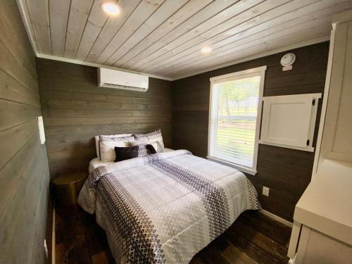 a bedroom with a bed in the corner of a room at Cozy Tiny Home with Patio - 1 Mile to Town in Fredericksburg