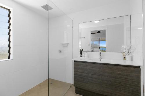 a bathroom with a sink and a mirror at Stunning Coastal 3 Bedroom Apartment in Cairns CBD in Cairns