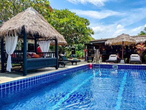 een zwembad met stoelen en parasols naast een resort bij Wirason Residence in Lamai