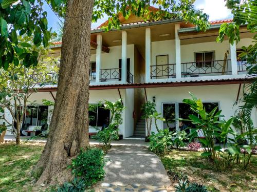 una casa con un árbol delante de ella en Wirason Residence, en Lamai