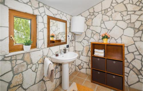 a bathroom with a sink and a stone wall at Beautiful Home In Krbune With Wifi in Krbune