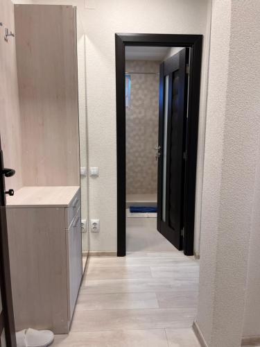 a bathroom with a sink and a door to a room at Barney Apartman in Sovata