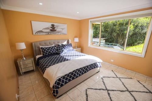 um quarto com uma cama grande e uma janela em Entire House Beautiful Farm Stay 9 Bedrooms Sleeps 18 Enjoy Nature em Mangrove Mountain