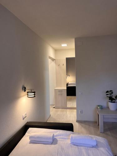 ein Schlafzimmer mit einem Bett mit zwei weißen Handtüchern darauf in der Unterkunft Barney Apartman in Sovata