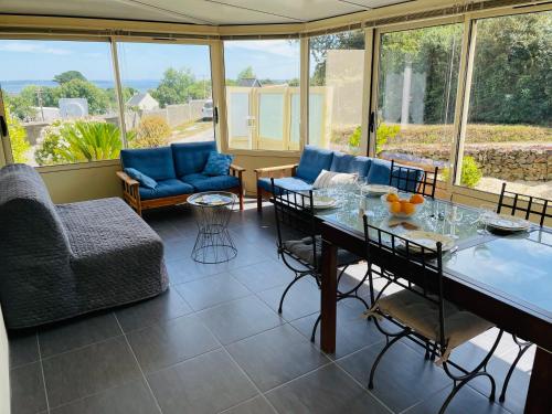 sala de estar con mesa y sillas en Maison spacieuse à deux pas de la plage, en Roscanvel