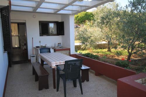 eine Terrasse mit einem Tisch und Stühlen sowie eine Küche in der Unterkunft Apartments by the sea Lukoran (Ugljan) - 8397 in Lukoran