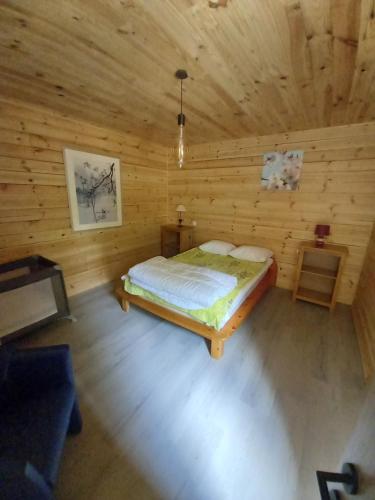 ein Schlafzimmer mit einem Bett in einer Holzhütte in der Unterkunft Le chalet des Oisaï in Wibrin