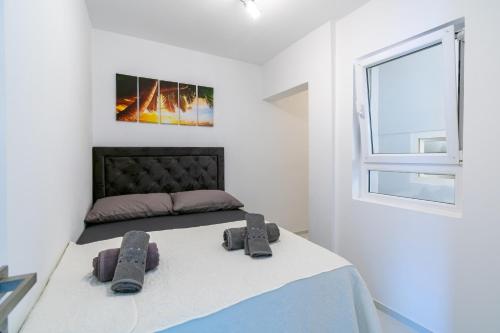 ein Schlafzimmer mit einem Bett mit zwei Hausschuhen darauf in der Unterkunft Apartments by the sea Poljana, Ugljan - 8419 in Poljana