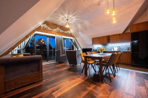 a kitchen and dining room with a table and chairs at Apartamenty Polana pod Nosalem - zachód in Zakopane