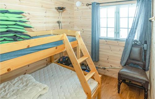 a bedroom with a bunk bed and a chair at Stunning Home In Tjrhom With Wifi And 8 Bedrooms in Tjørhom