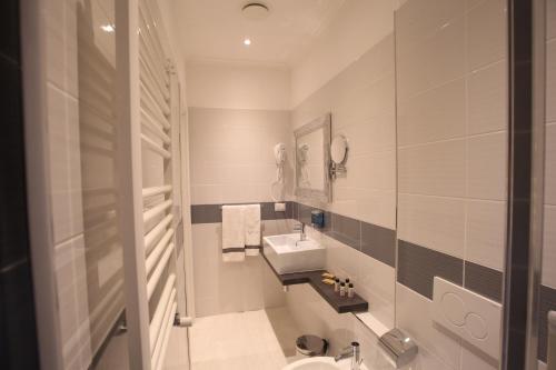 un bagno bianco con lavandino e specchio di Guesthouse Interno 7 Luxury Rooms a Roma