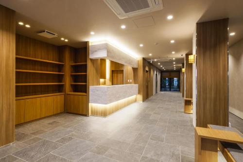 einen Flur mit Holzvertäfelung und eine Lobby in der Unterkunft Plum Hotel in Osaka
