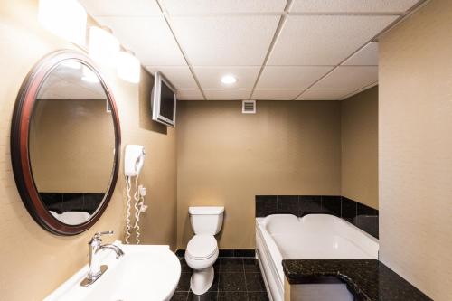a bathroom with a sink and a tub and a toilet at Holiday Inn South Plainfield-Piscataway by IHG in South Plainfield