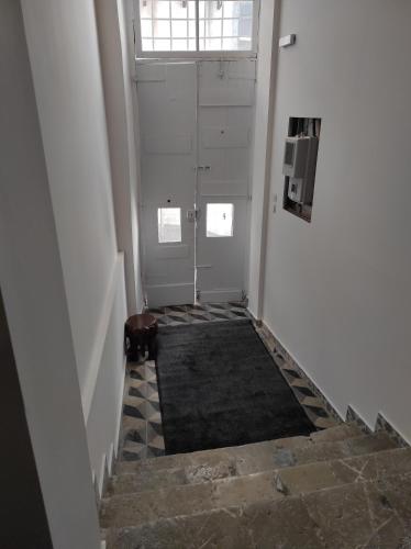 a hallway with a stairway with a door and a window at 1830 Chateau in Nafplio