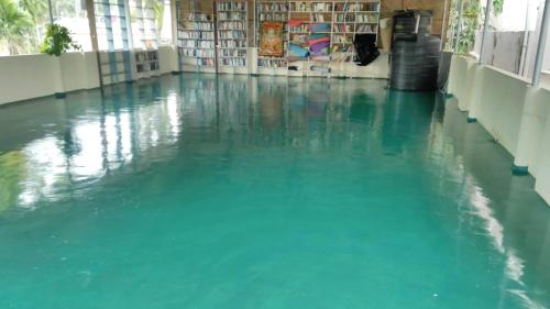 una gran piscina de agua en una habitación con suelo en Marina guest house, en Kovalam