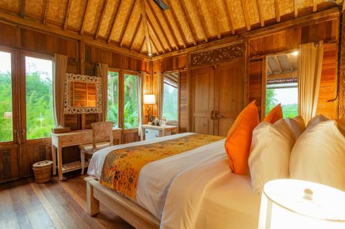a bedroom with a bed and a desk in a room at Nauna Villa Ubud in Ubud