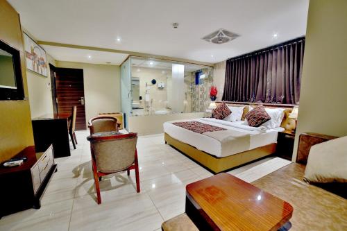 a hotel room with a bed and a living room at Hotel Kings Heritage Surat in Surat