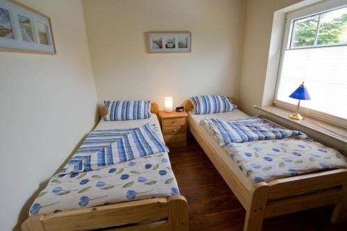 2 aparte bedden in een kamer met een raam bij Nordlicht in Norddeich