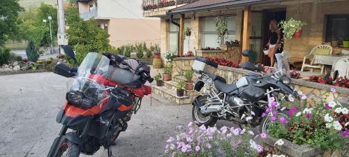 two motorcycles parked in front of a building with flowers at Apartman Lavanda in Drvar