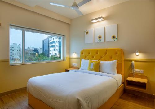 a bedroom with a large bed with a large window at Bloom Hotel - HITEC City in Hyderabad