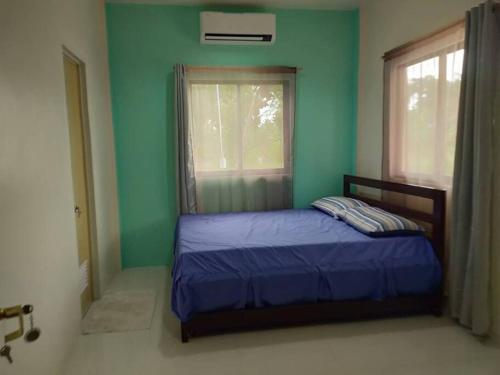 a bedroom with a bed with a blue wall and a window at Susana Goles Holiday House in Saavedra