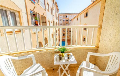 a balcony with two chairs and a table on a balcony at Cozy Apartment In Torrevieja With Wifi in Torrevieja