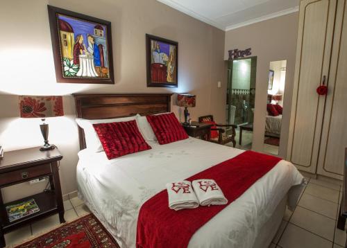 een slaapkamer met een bed met twee handdoeken erop bij @Home Guest House in Rustenburg
