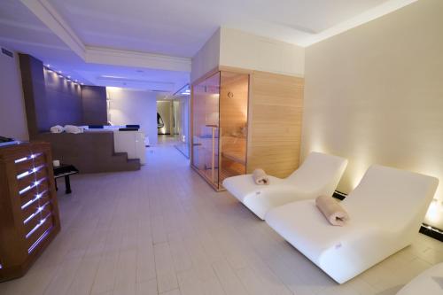 a living room with two white chairs in a room at Ludwig Boutique Hotel & Spa in Bolsena