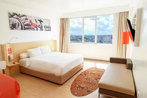 Postel nebo postele na pokoji v ubytování HARRIS Hotel Pontianak