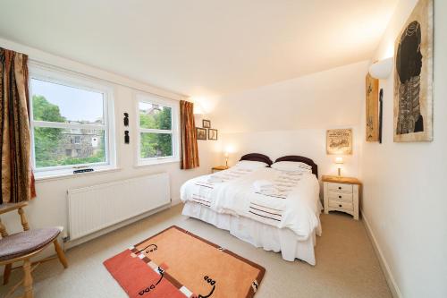 a bedroom with a bed and a large window at Earnside Cottage in Comrie