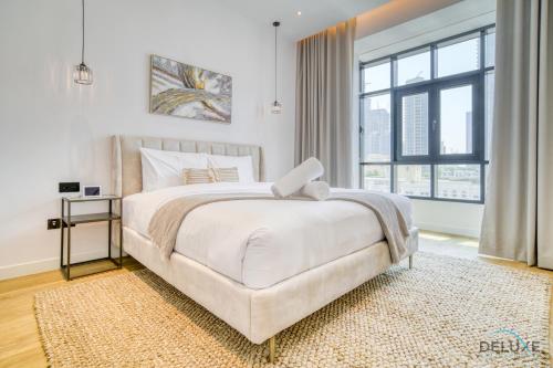 sypialnia z dużym łóżkiem i dużym oknem w obiekcie Phenomenal 1BR at Al Tajer E Downtown Dubai by Deluxe Holiday Homes w Dubaju