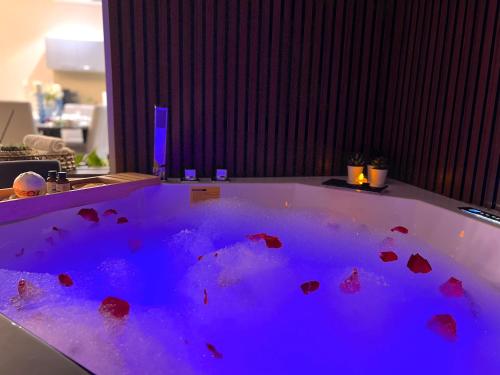 a jacuzzi tub with blue lighting in a room at Stylish Apartment with a Jacuzzi (Park&Pool View) in Muscat