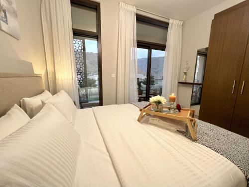 a bedroom with a large bed with a table on it at Stylish Apartment with a Jacuzzi (Park&Pool View) in Muscat