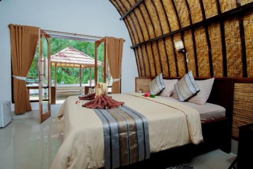 een slaapkamer met 2 bedden en een groot raam bij Warna Beach Hotel in Gili Trawangan