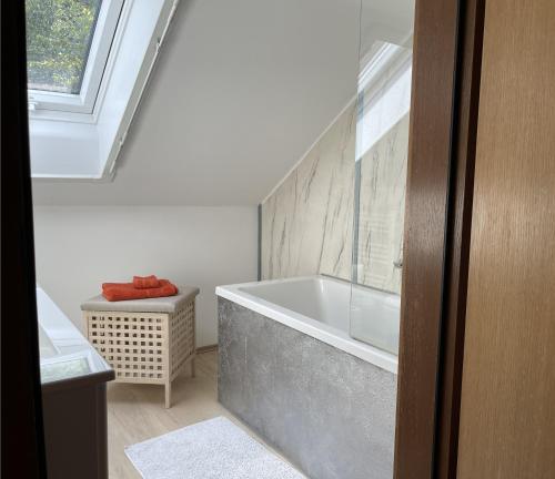 La salle de bains est pourvue d'une baignoire et d'une fenêtre. dans l'établissement Ferienwohnung am Kieferbach, à Kiefersfelden